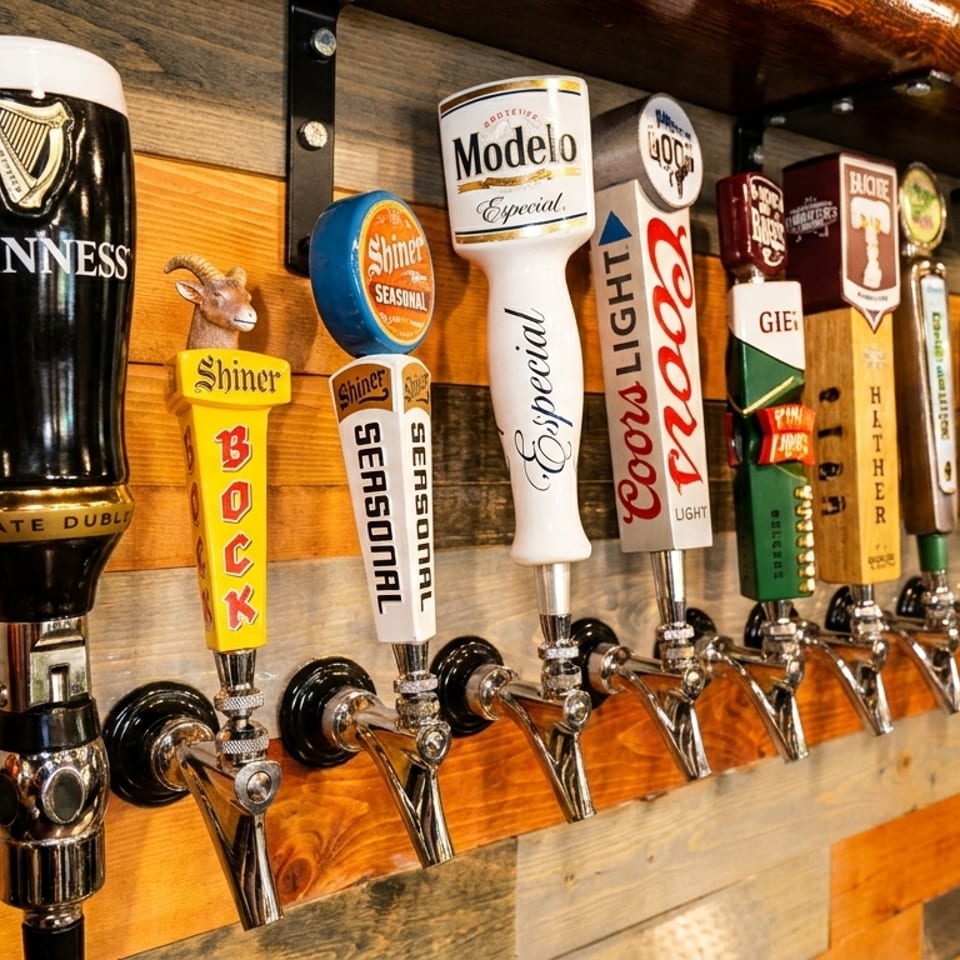 A row of beer taps with various brands, including Guinness, Modelo, and Coors Light.